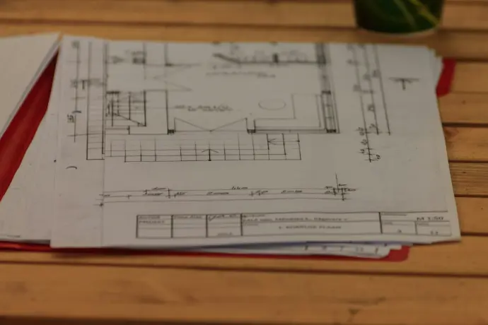 A wooden table topped with lots of papers